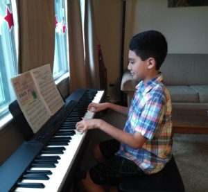 A delighted student plays beautiful piano melodies.